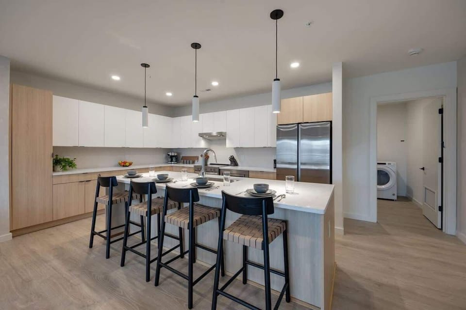Kitchen stocked with all culinary essentials and fully equipped with brand-new stainless-steel appliances. Features an island with bar seating.