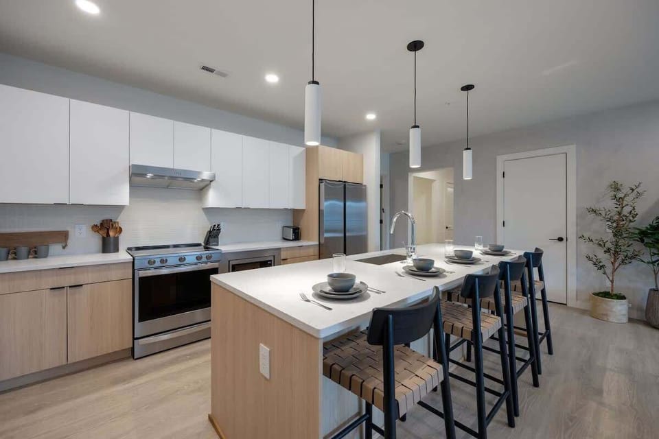 Kitchen stocked with all culinary essentials and fully equipped with brand-new stainless-steel appliances. Features an island with bar seating.