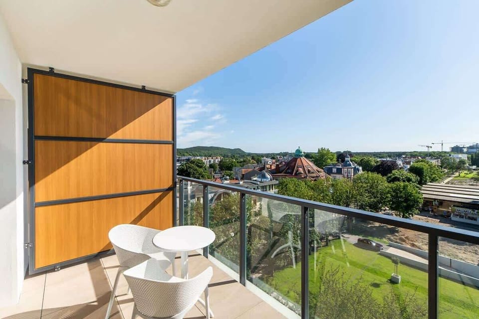 A view of the balcony with a small table and chairs, offering a peaceful outdoor retreat with scenic surroundings.






