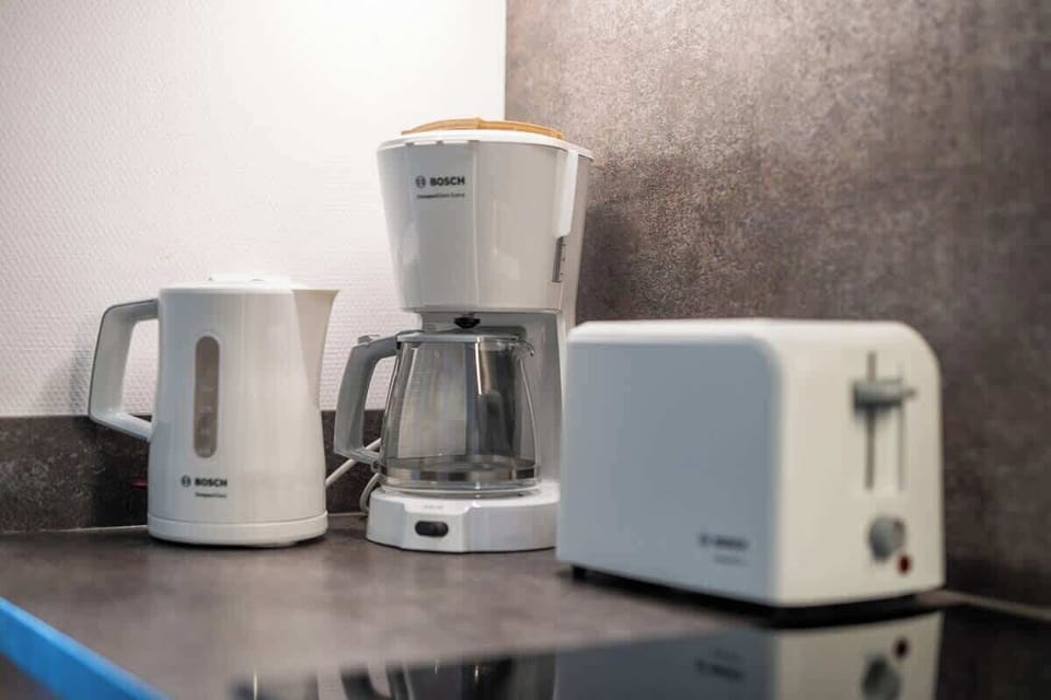 A coffee and tea station featuring a kettle, coffee maker, and toaster on a countertop, adding convenience and comfort.
