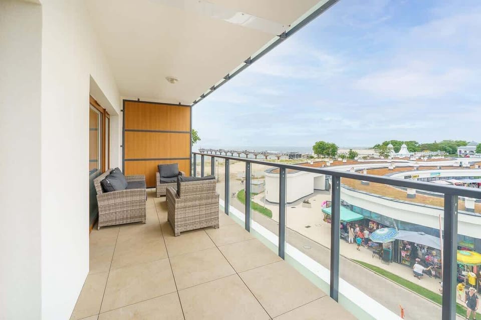 A balcony with modern furnishings, offering a comfortable seating area and a scenic view of the surroundings.
