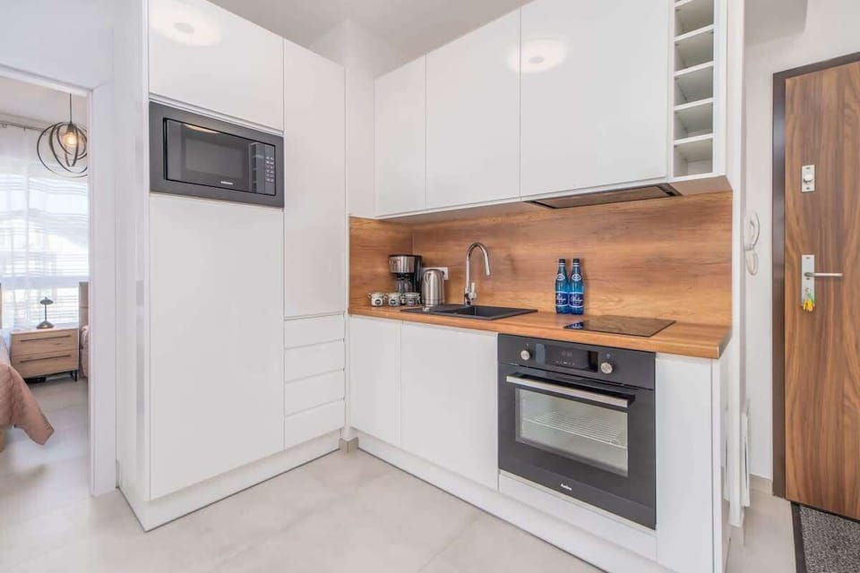 Kitchenette with plenty of kitchen utensils and dishes. 