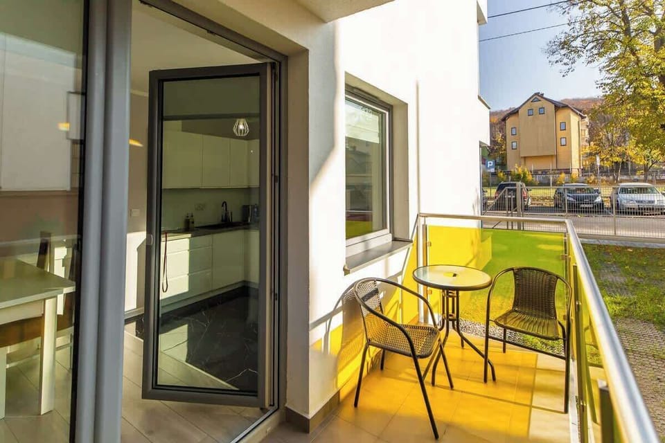 Another view of the balcony with seating, showcasing a sunny and inviting outdoor space.
