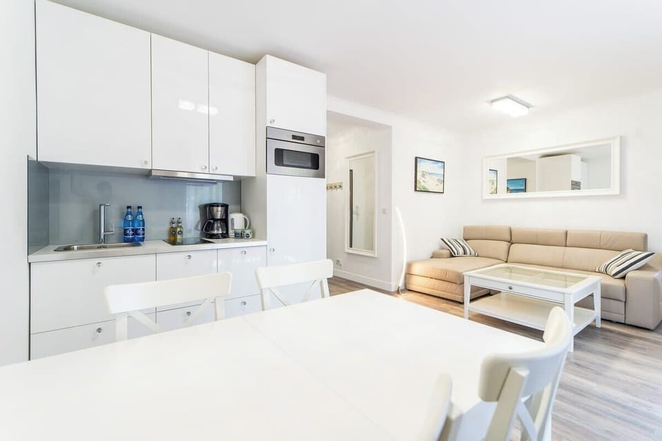 An open-plan kitchen and living space with modern furnishings and bright lighting, combining style and practicality.
