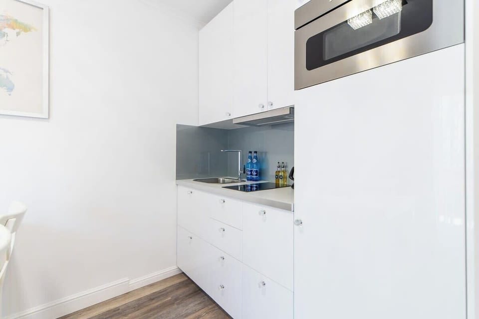A compact kitchen with white cabinets, modern appliances, and a clean, functional layout.
