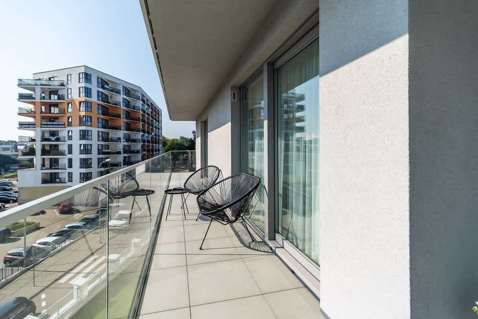 Another angle of the balcony, showing the seating area and the view of surrounding modern buildings.

