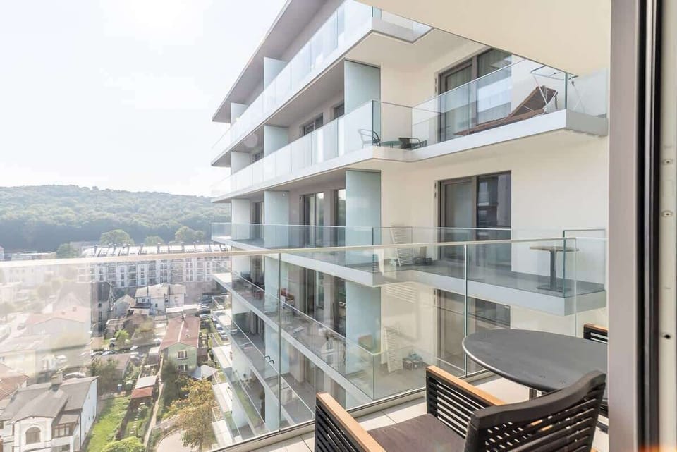 Another angle of the balcony, highlighting its glass railing and modern furnishings with a view of the surroundings.







