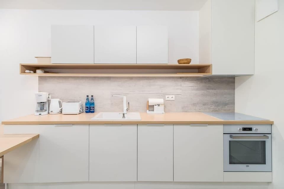 A close-up of the kitchen's open shelving, white cabinetry, and modern appliances.
