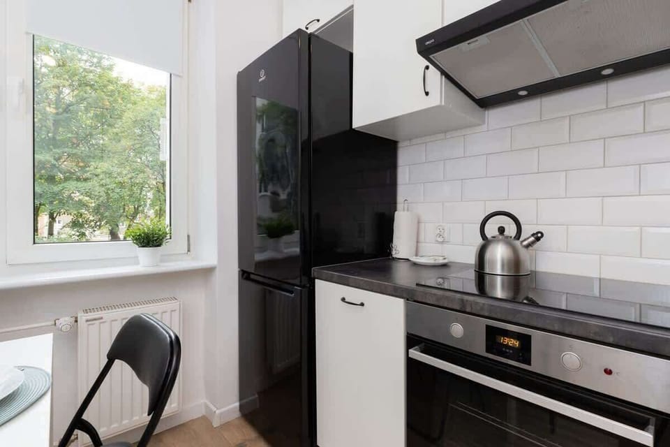 Another view of the modern kitchen, showcasing black cabinetry, a kettle, and bright natural light.






