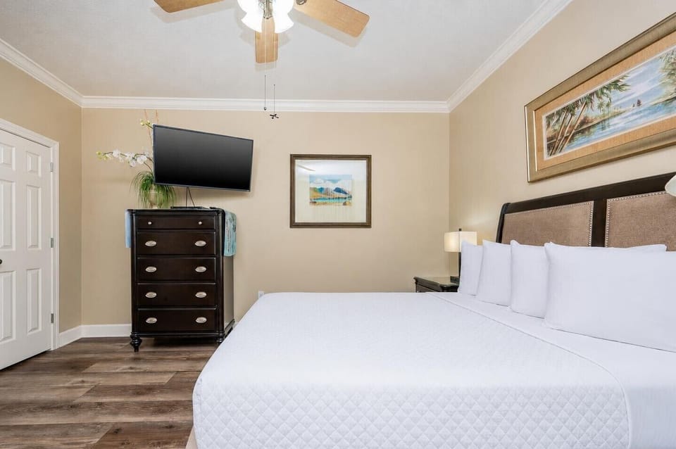Relax in the comfortable guest bedroom featuring a queen bed, a large TV, and tasteful decor for a restful stay
