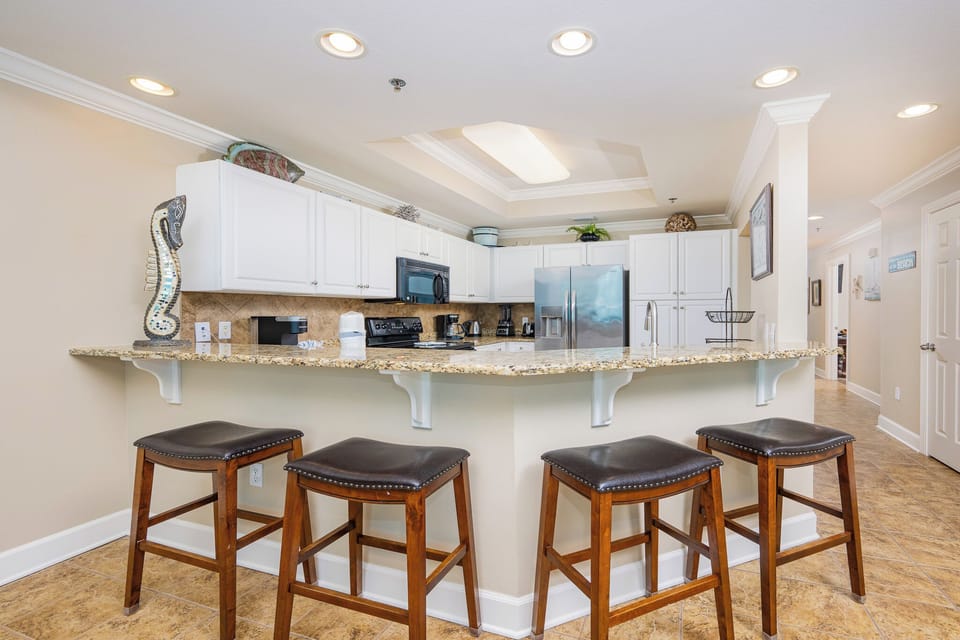 Gather around the granite breakfast bar with stylish stools, perfect for casual meals or morning coffee