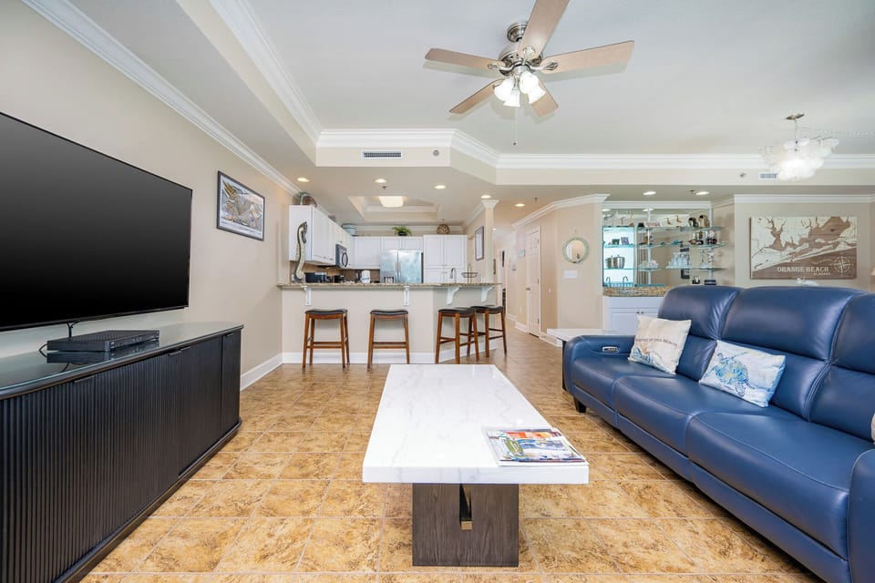 Relax in the inviting living area with a plush sofa, sleek coffee table, and a large TV for entertainment