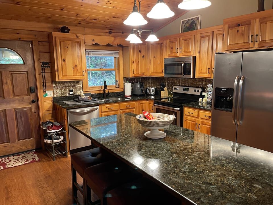 Warm wood interior featuring full kitchen, dining island, and open living space.