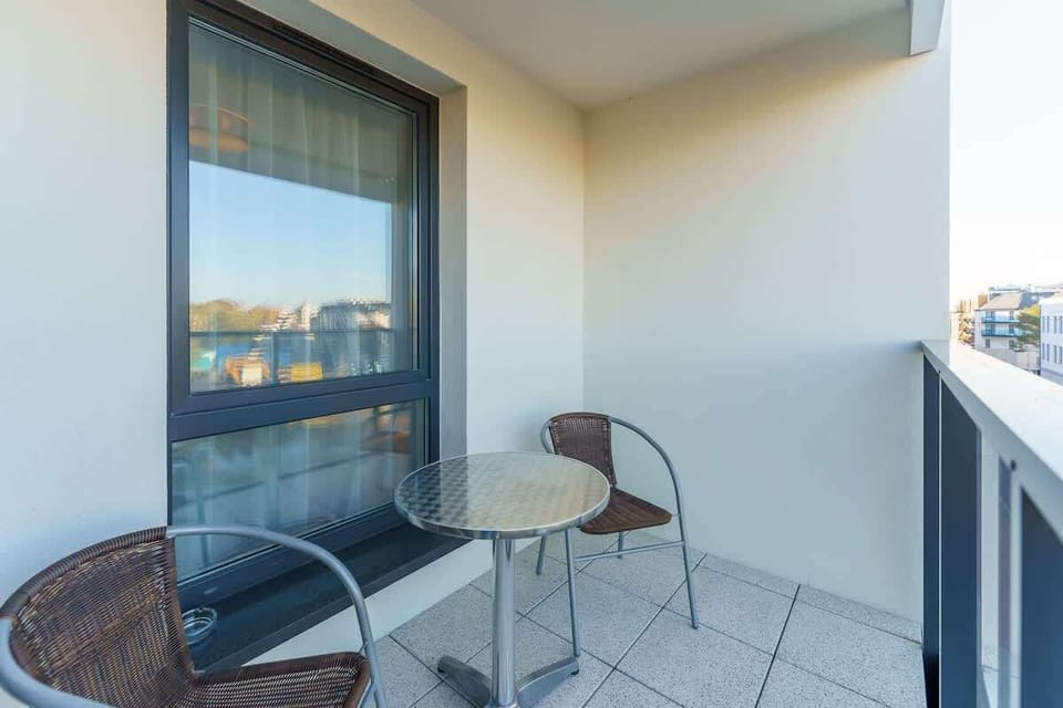 Spacious balcony with outdoor furniture. 