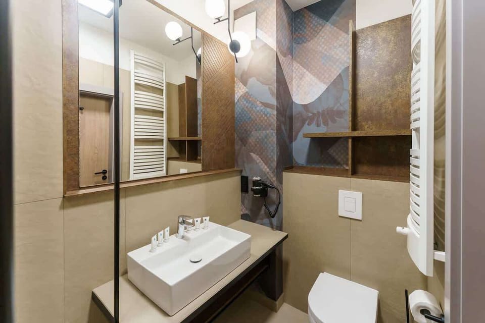 The bathroom's contemporary design includes fresh towels and a hairdryer. 