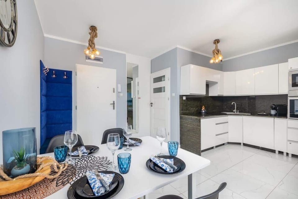 A dining table set with blue accents and decorative tableware, positioned near the living area.
