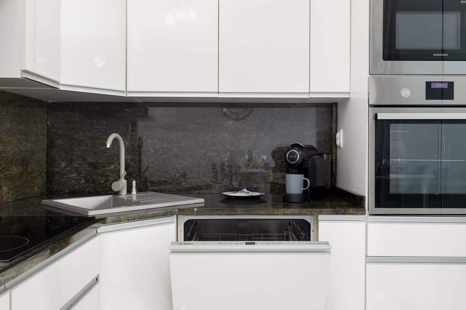 A close-up of the kitchen sink and countertops, emphasizing the clean, modern design.
