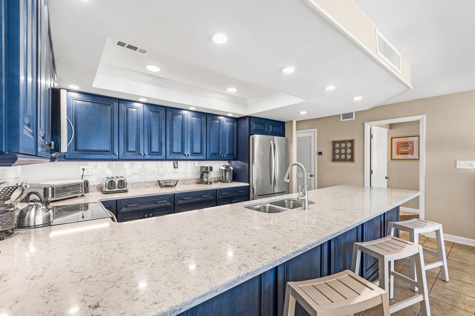 Your gourmet kitchen features stunning navy cabinets, gleaming granite countertops, and stainless steel appliances perfect for creating memorable meals during your stay.