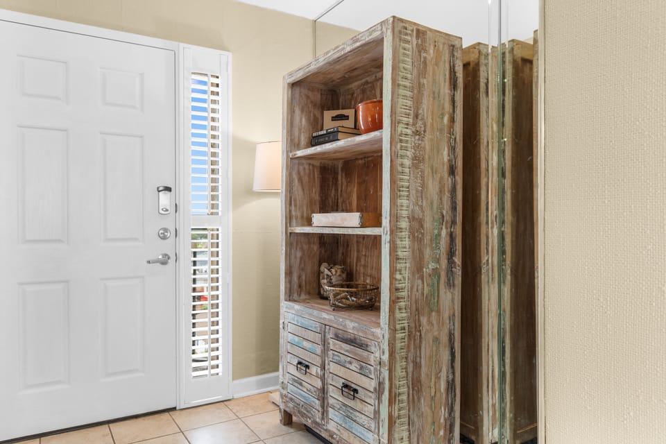 Step into your coastal retreat where rustic charm meets comfort. This weathered storage cabinet adds character to your entryway.