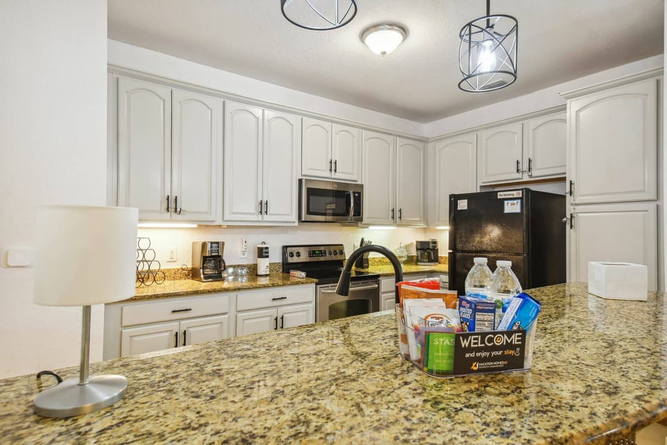 This bright kitchen boasts granite countertops and warm wooden cabinets, creating a cozy yet functional space. Modern stainless steel appliances enhance the atmosphere, making it ideal for family meals or quick snacks.
