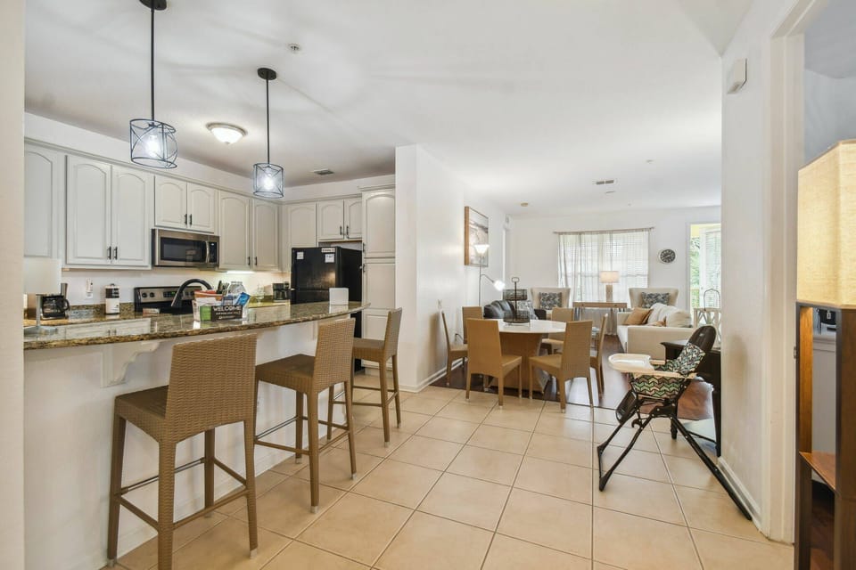 Step into a spacious kitchen featuring sleek granite countertops and light cabinetry that complements the open layout. With stylish bar seating and a cozy dining area, it's an ideal spot for casual meals and gatherings.