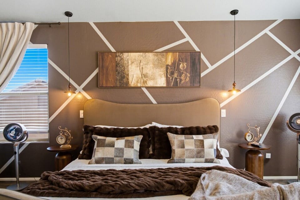 👑 Elegant Primary Bedroom Retreat — Relax in a beautifully designed king bedroom featuring modern décor, stylish lighting, plush bedding, and a peaceful atmosphere for a comfortable stay.