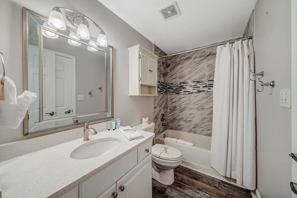 The bathroom has been nicely updated with a tiled shower/tub combo and quartz countertop.