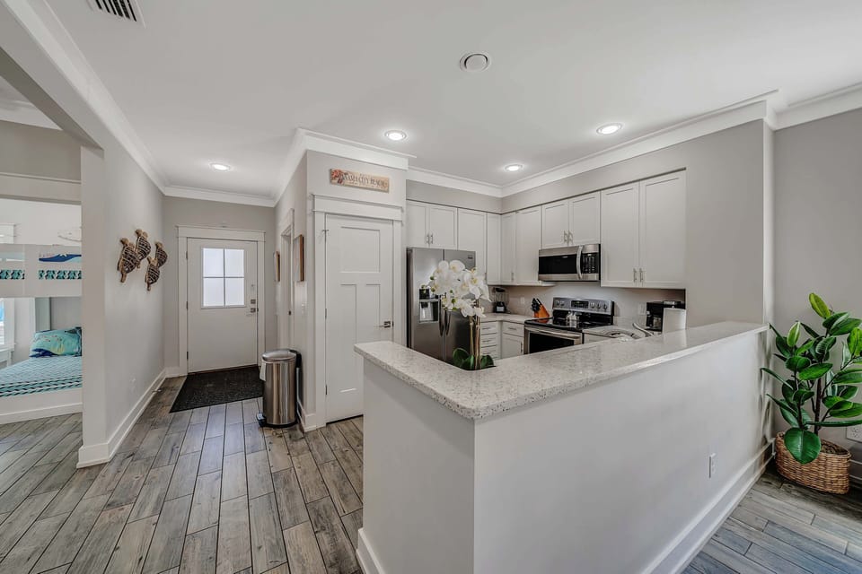 The fully equipped kitchen features beautiful recycled glass countertops and stainless-steel appliances.