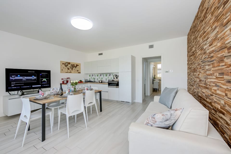 Living room with sofa bed, dining table and direct access to the terrace