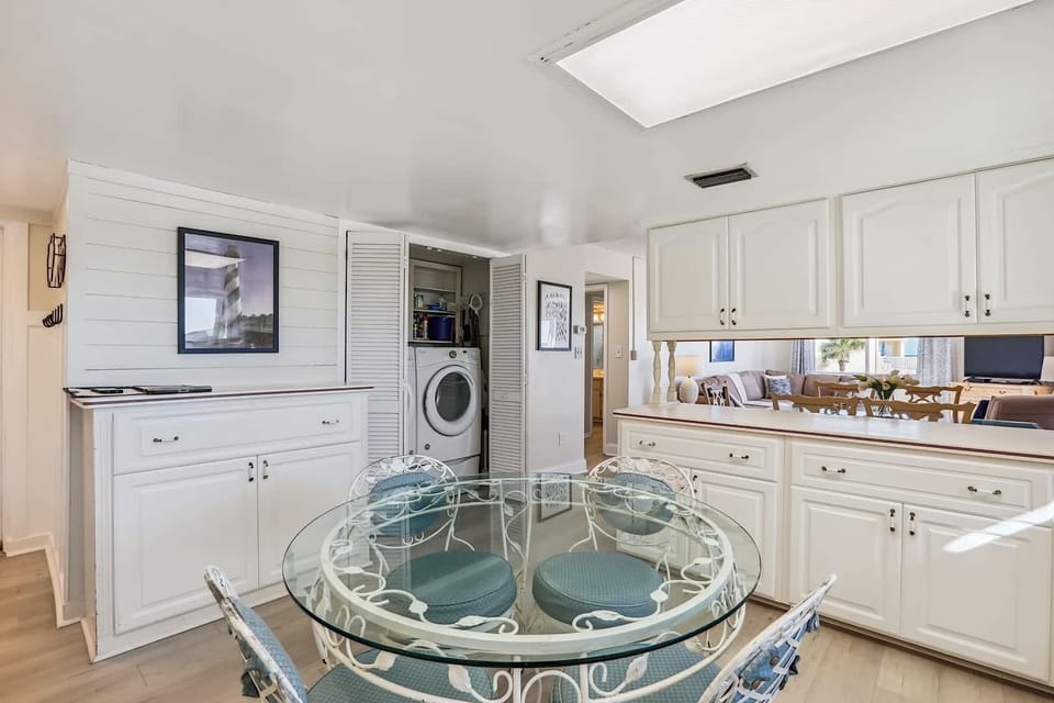 - Kitchen area with washer dryer unit making laundry easy during long vacations  
- Round glass dining table and cabinets provide comfort and functionality daily  
- Perfect for extended stays offering all in home conveniences for guest comfort