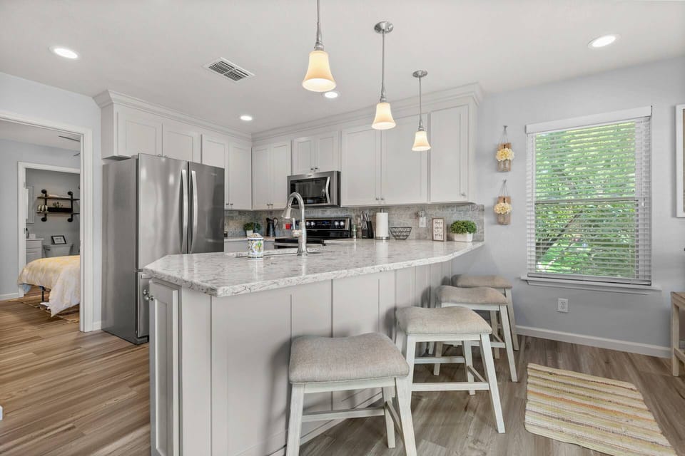 Modern full-sized kitchen with stainless steel appliances and convenient barstool seating for a relaxed dining experience.
