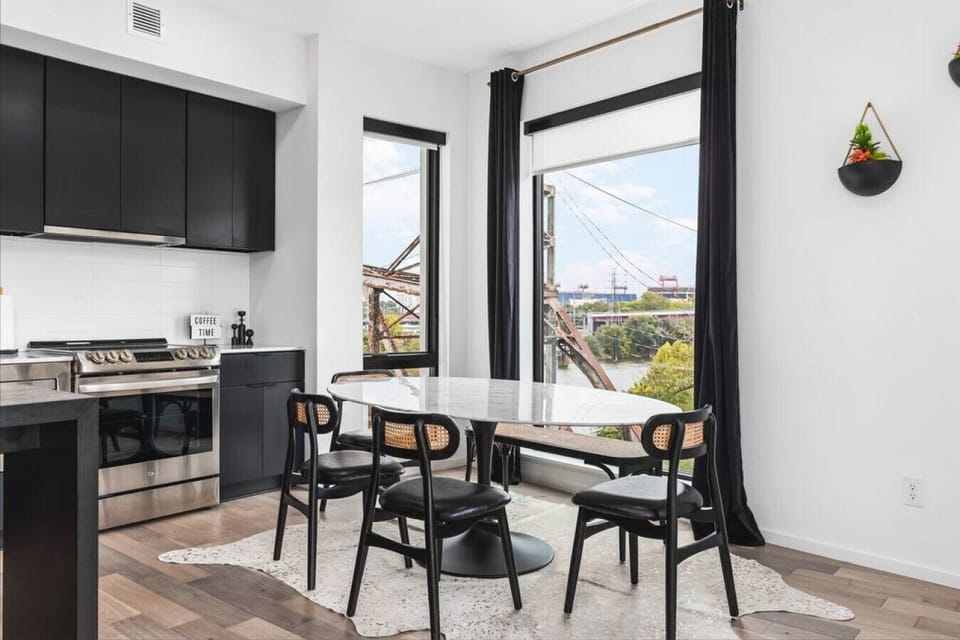 Dining area with seating for six overlooking the train bridge and Nissan Stadium across the Cumberland river.