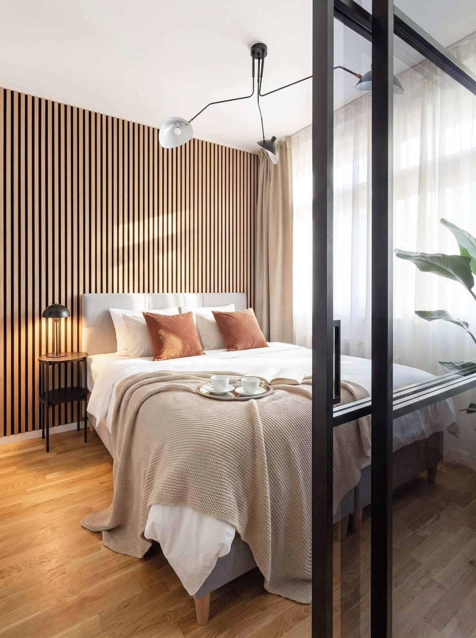 Second bedroom separated from the living room with a glass wall and blinds.