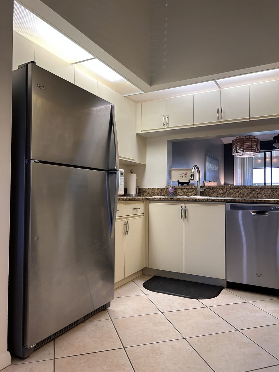 Kitchen with stainless steel refrigerator and dishwasher. Granite countertop. 