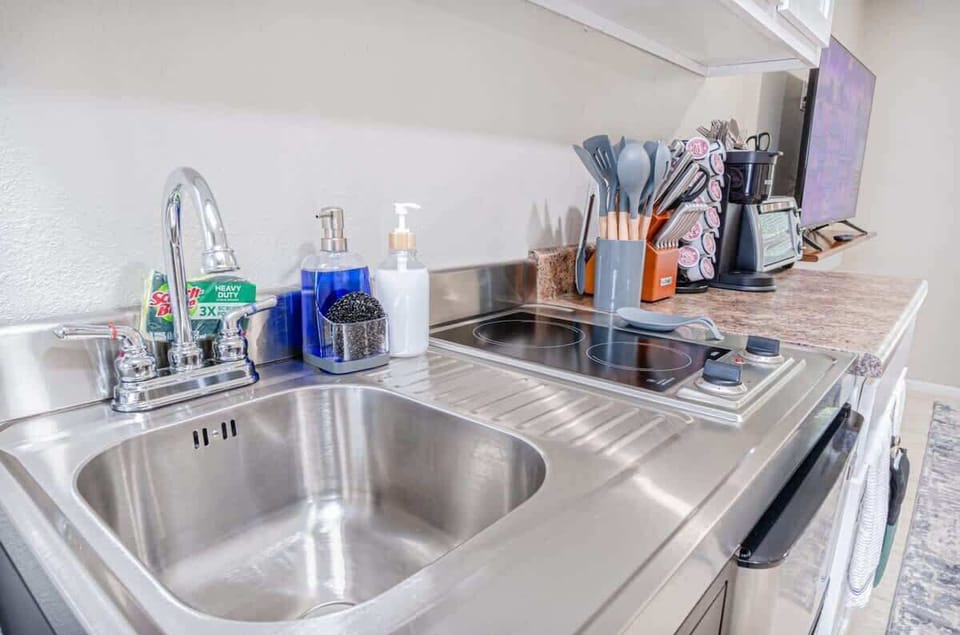 Clean and functional kitchen setup with sink and essential utensils—everything you need for easy meal prep during your stay.