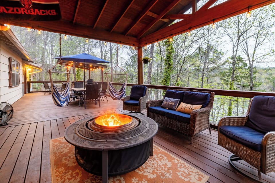 Spacious covered deck with fire pit, lounge seating, and hammock chairs.