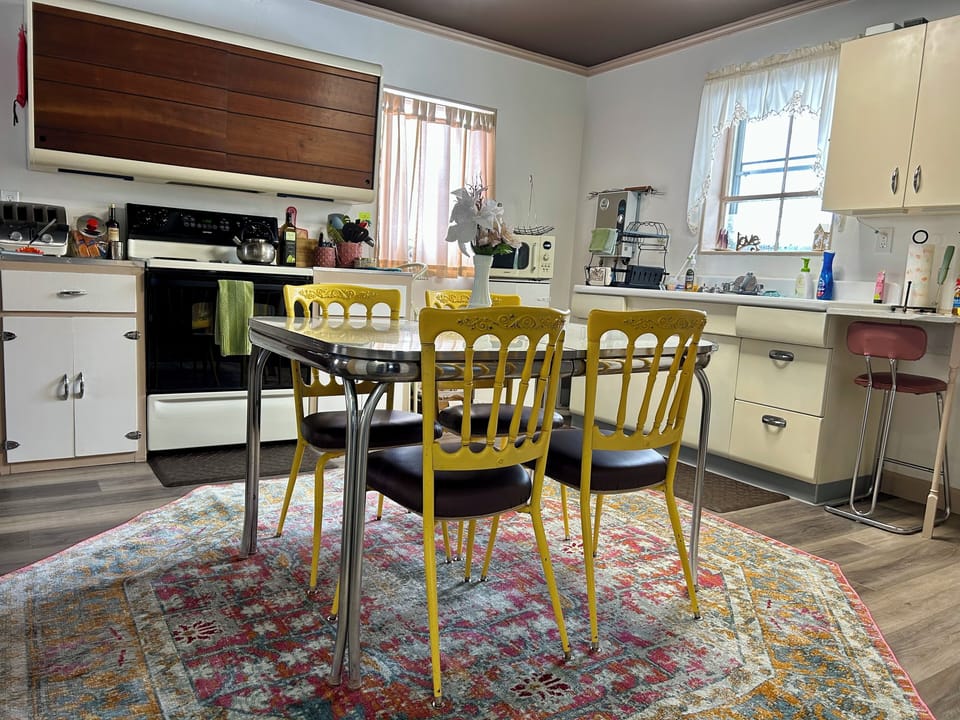 Dining table seats 4 comfortably, but can fit up to six. Two more chairs inside.