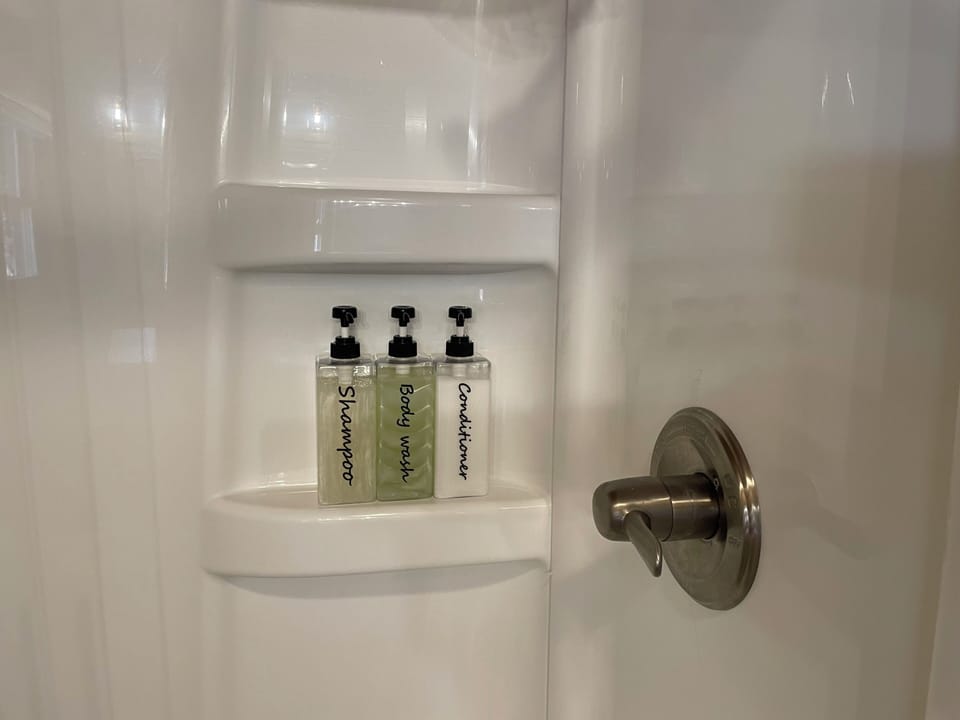 Bright shower with built-in shelves and stocked bath essentials