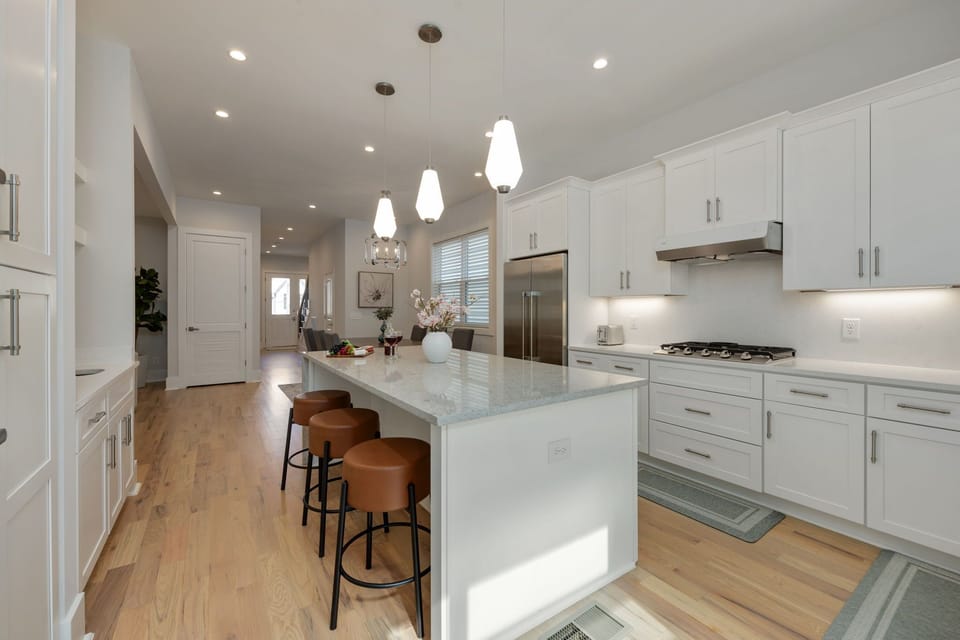 (1st Floor) Fully-equipped kitchen with stainless steel appliances, basic cooking essentials, and kitchen island seating.