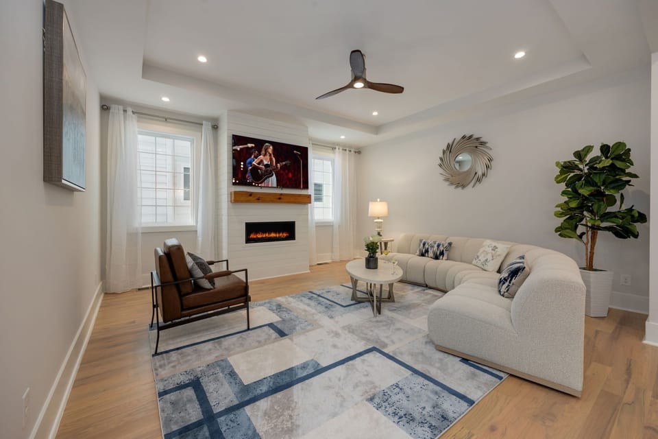(1st Floor) Spacious living room with multiple seating, smart TV, and fireplace.