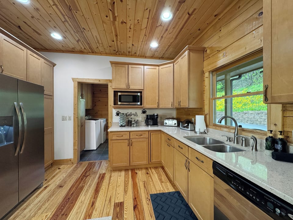 Cook, gather, and enjoy in this spacious kitchen featuring a large island with bar seating. Perfect for group meals or casual snacks, it’s fully equipped and designed for connection—whether you're cooking or just keeping the chef company.