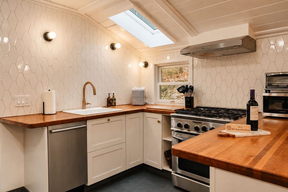Fire up the gas range under the hood and rinse produce at the sink with the gold faucet. Open a bottle of wine on the counter and let the skylight bring in daylight while you cook up something on the tile backsplash counters.
