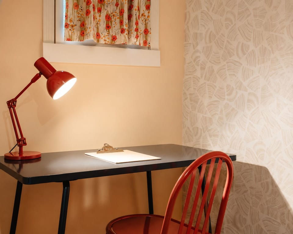 Sit at the desk and switch on the red lamp for a bit of work, answering emails or catching up on backlogs. The window with the floral curtain lets in some daylight if you want to skip the lamp during the day.