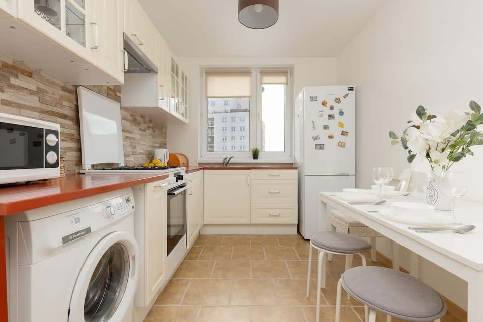 A functional kitchen with integrated appliances, a dining space, and natural light.
