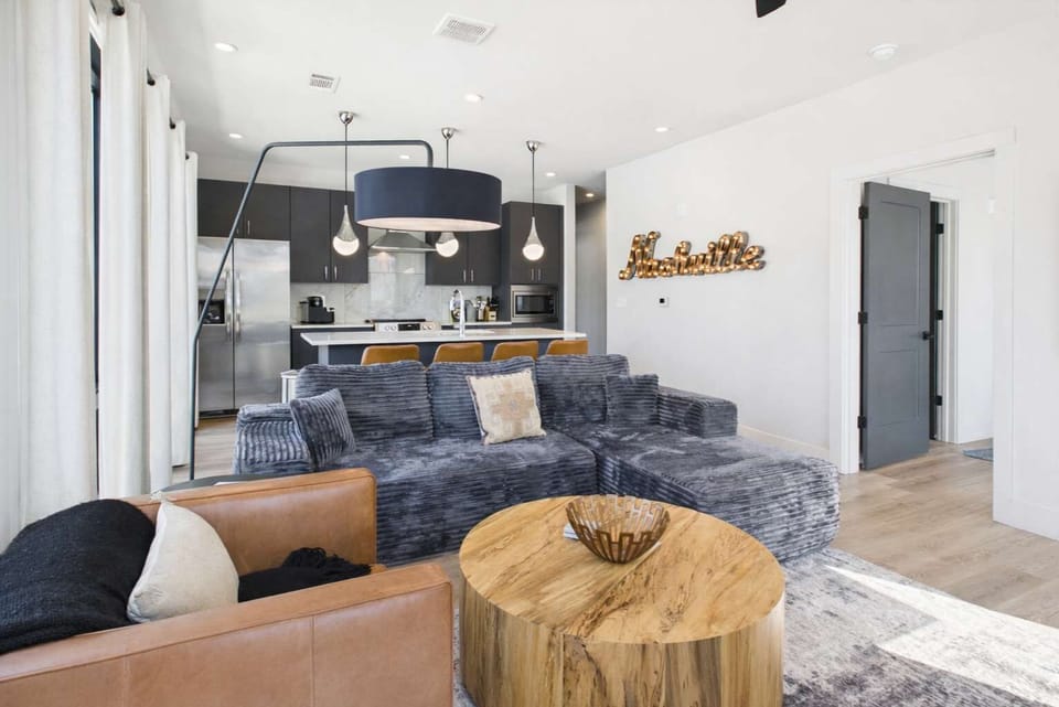 Bright living room with comfortable seating, smart TV, designer decor, and access to the private patio.