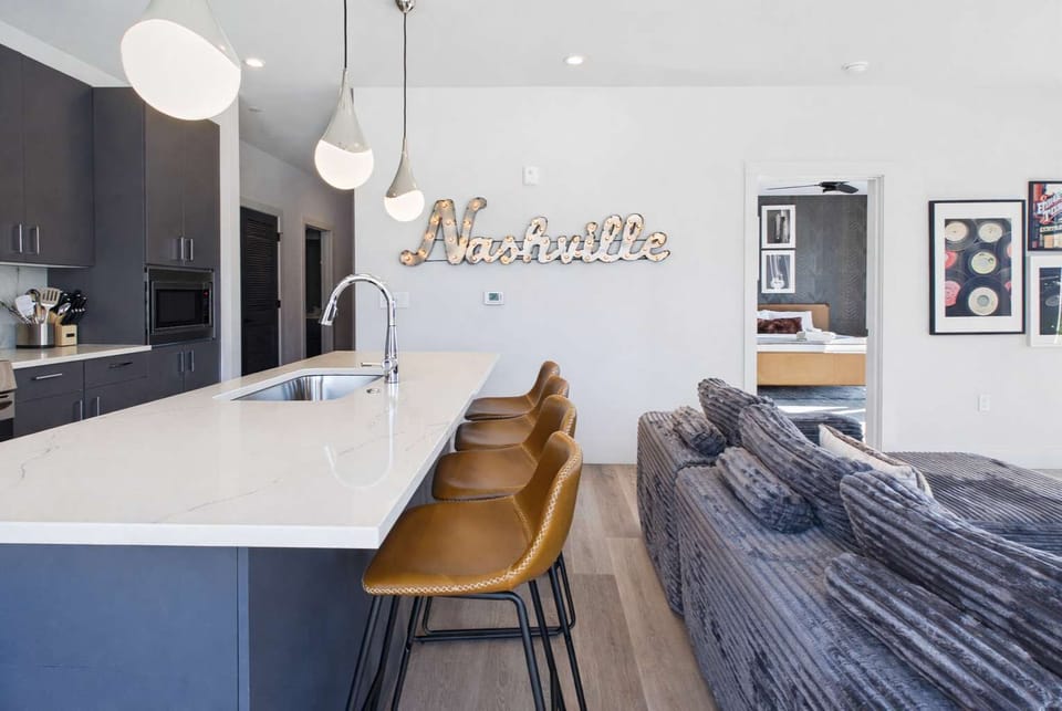Bright living room with comfortable seating, smart TV, designer decor, and access to the private patio.
