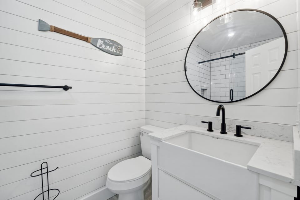 Modern bathroom with shiplap walls and a round mirror
