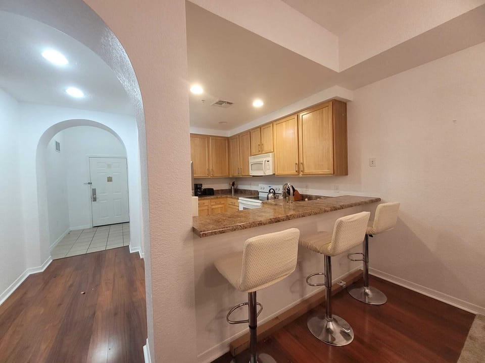 ENTRANCE FOYER AND BAR STOOLS FACING THE KITCHEN