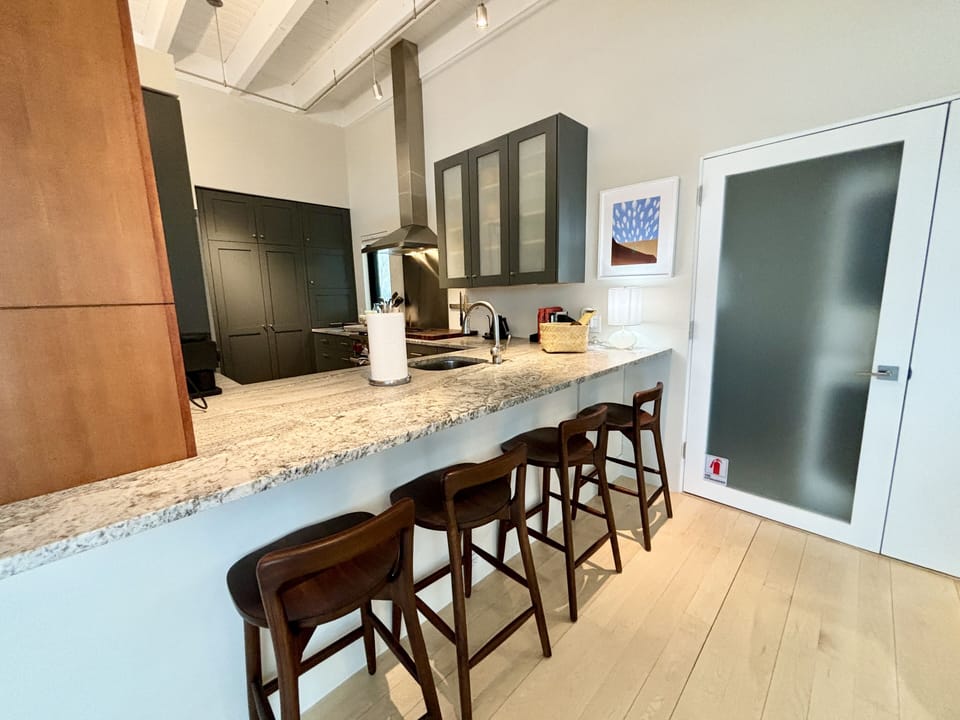 A kitchen with a bar and stools.