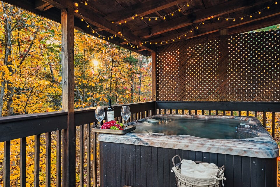 Relax in Beary Tale's bubbling hot tub amidst fall foliage. Fits 4 adults.